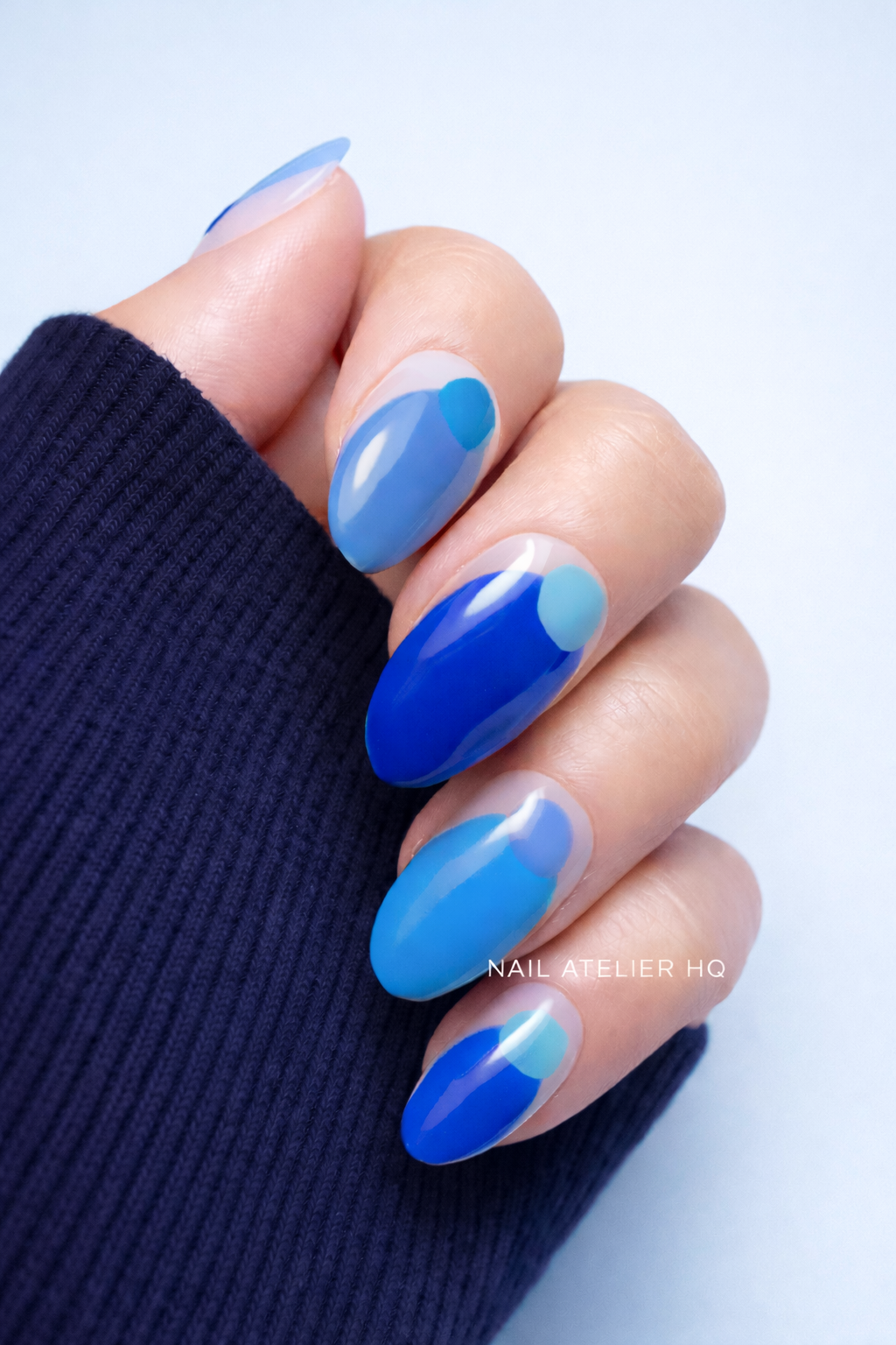 Hand with blue gel polish on a light background
